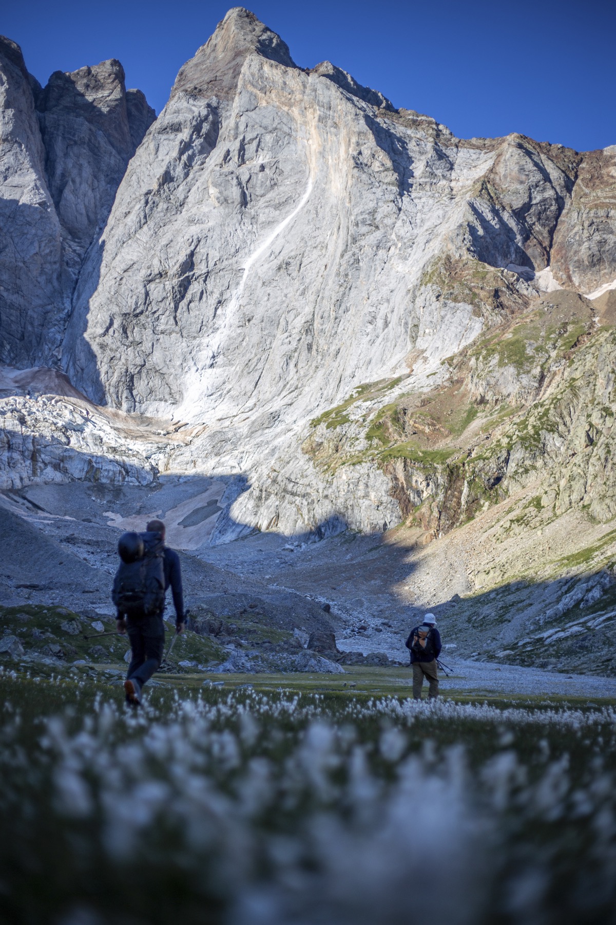 Marcheurs face à une grande paroi pyrénéenne