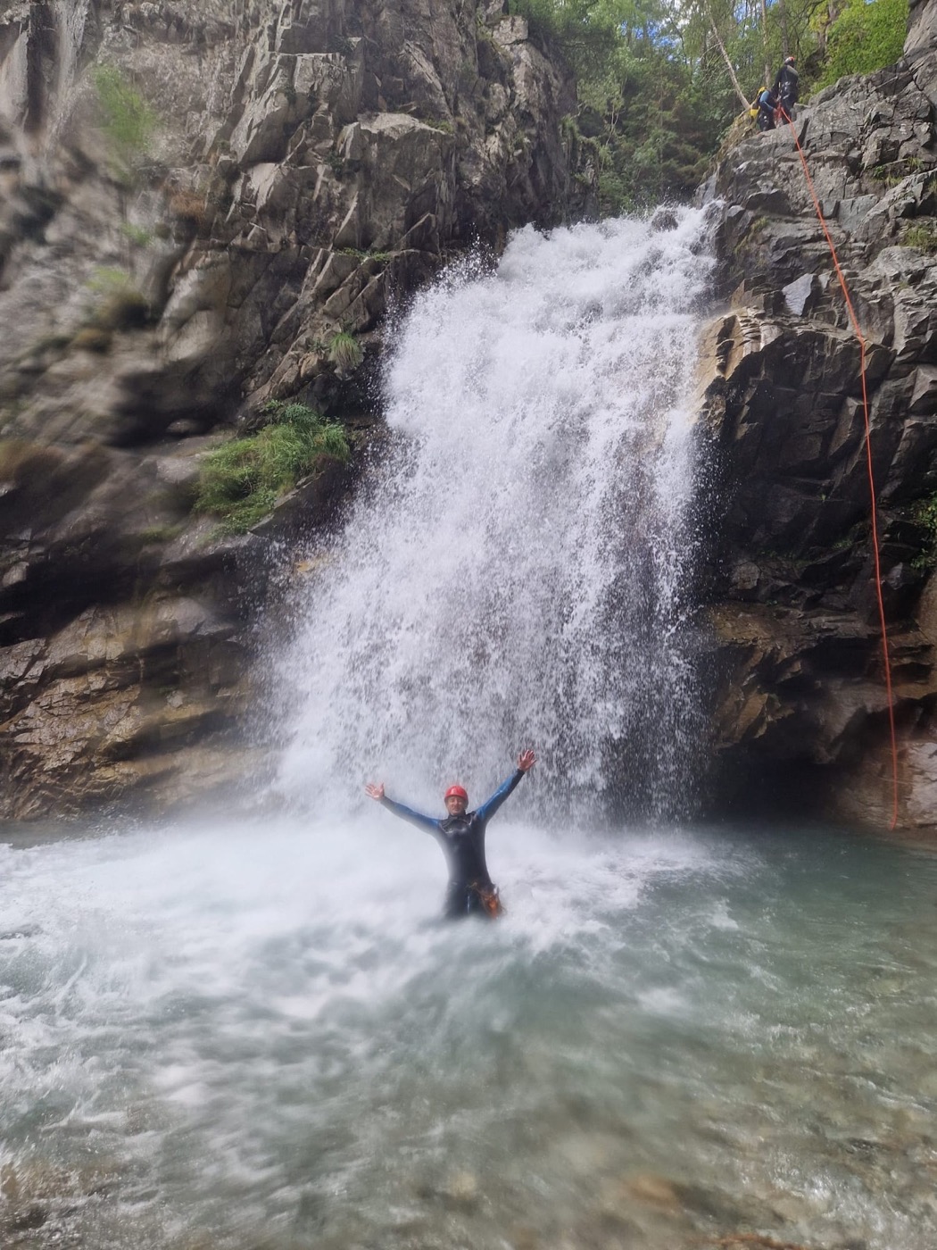 Participante al pie de una cascada durante el curso