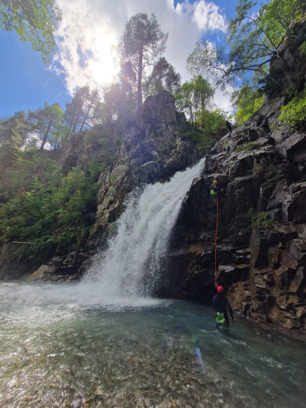 Aprendizaje del rápel junto a una cascada