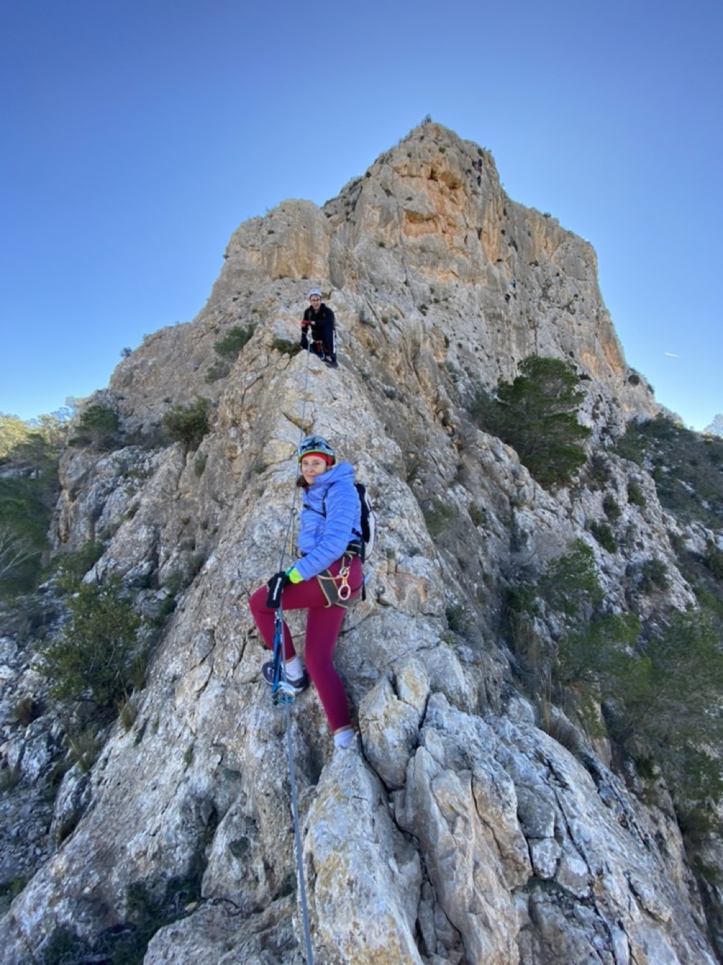 Participante avanzando por el cable de una vía ferrata en cresta